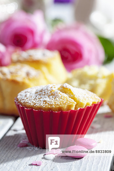 Muffins  Backdekor und rosa Rosen auf dem Tisch