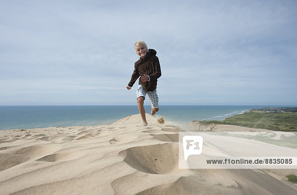 Denmark  Jutland  Rubjerg Knude  running boy on giant sand dune