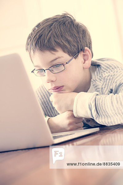 Portrait of boy using laptop at home