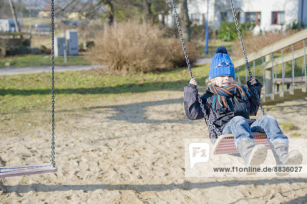 Germany  Mecklenburg-Western Pomerania  Ruegen  little boy swinging at playground