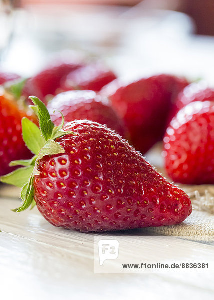 Erdbeeren auf Tuch und Holztisch