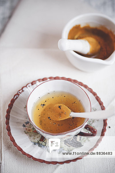 Tasse Kurkuma-Tee mit Pfeffer gewürzt