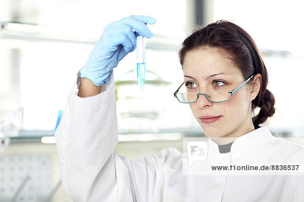 Porträt einer jungen Wissenschaftlerin bei der Arbeit im Labor