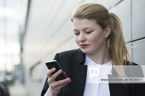 Junge Geschäftsfrau mit Handy