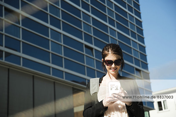 Portrait of young business woman using smartphone