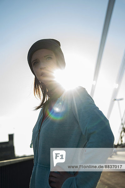 Portrait of young female jogger at backlight