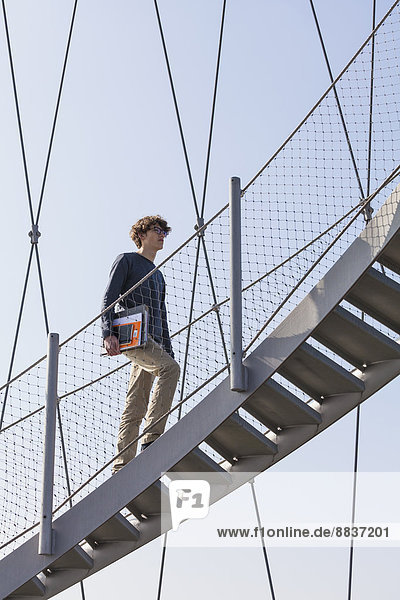 Teenager Junge  der die Treppe des Killesbergturms erklimmt.