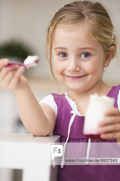 Portrait of little girl offering yogurt