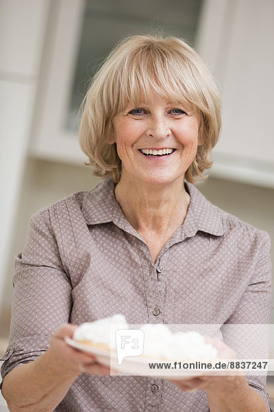Portrait of senior woman holding dish of waffles
