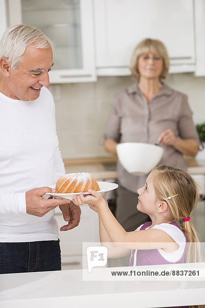 Seniorenpaar mit Enkelin in der Küche