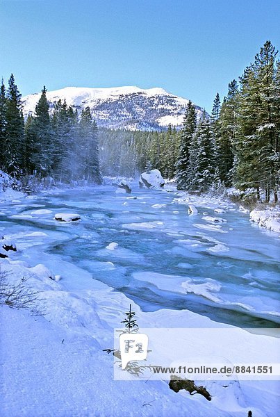 A snowy winter scenic of Maligne River in Jasper National Park Alberta Canada