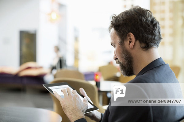 Businessman using digital tablet in hotel restaurant