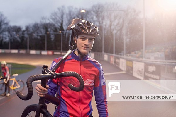 Porträt eines jungen Radfahrers mit Fahrrad auf dem Velodrom