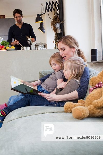 Mutter und zwei Töchter lesen Märchenbuch
