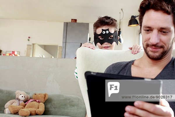 Maskierter Sohn lenkt Vater vom digitalen Tablett ab