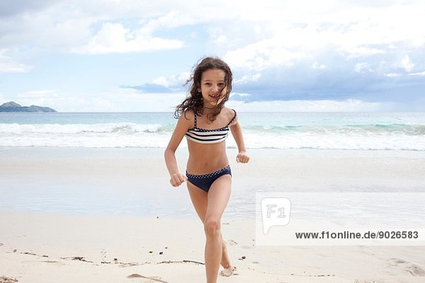 Girl running on beach in Seychelles