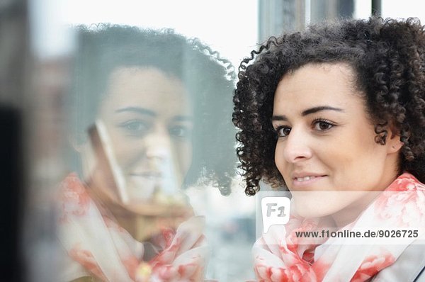 Nahaufnahme Porträt einer jungen Frau beim Schaufensterbummel