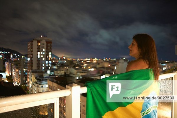 Reife Frau  die nachts vom Balkon blickt  Rio De Janeiro  Brasilien