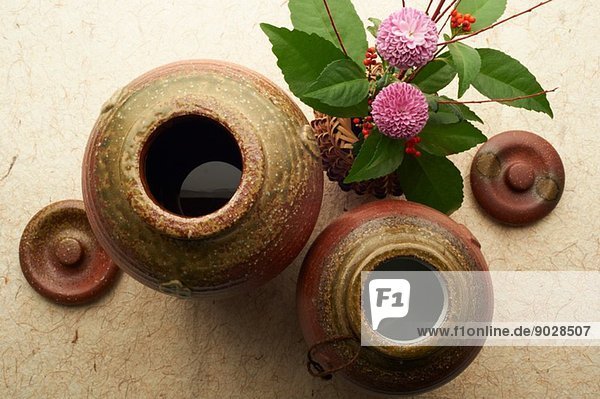 Stilleben von Keramikgefäßen und Deckeln mit Blumen- und Beerenvase