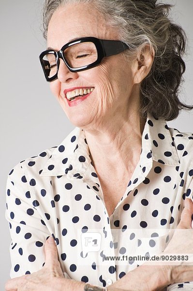 Porträt einer älteren Frau  Arme gekreuzt  lachend