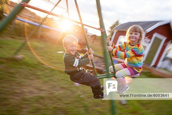 Boy and girl swinging  Norrbotten  Sweden