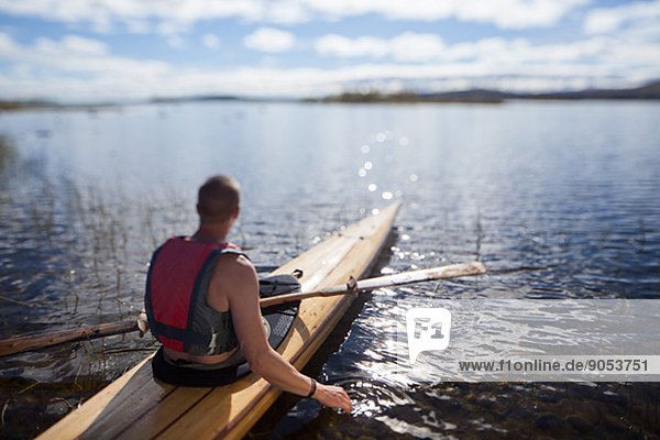 Young man canoeing  Norrbotten  Sweden