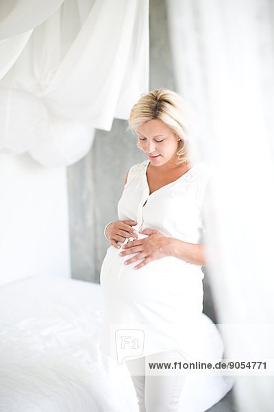 Pregnant woman in bedroom  studio shot