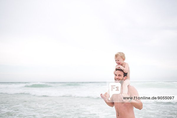 Father with child on beach in fog  Australia