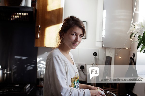 Smiling young woman in kitchen