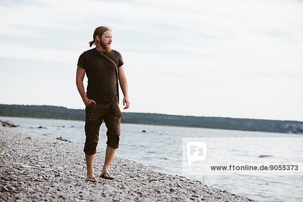 Young man standing on beach  Gotland  Sweden