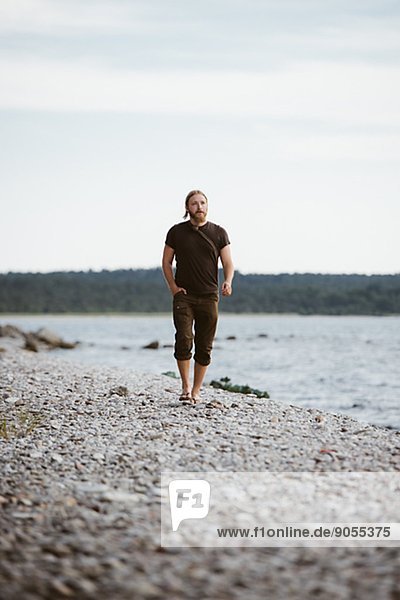 Young man walking on beach  Gotland  Sweden