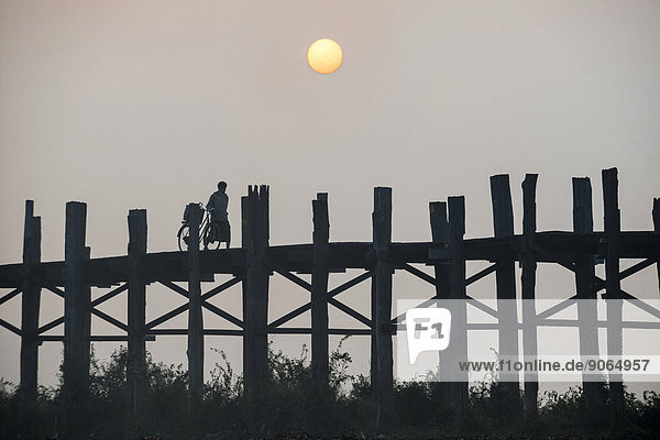 Mann über Sonnenaufgang See Brücke Fahrrad Rad Teakholz Myanmar Amarapura Mandalay Division