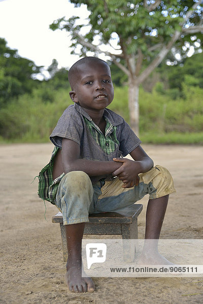 Boy sitting on a stool  Nkala  Bandundu Province  Democratic Republic of the Congo