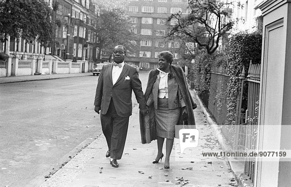 Louis Armstrong seen here arriving for a press conference at the Mayfair Hotel,  shortly before leaving for a tour of Africa accompanied by his wife Lucille. 12th October 1960