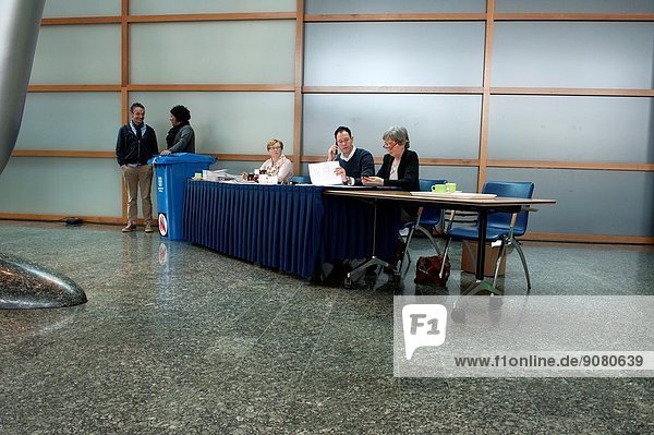 March 19  2014. Interpolis Building  Tilburg  Netherlands. Day of elections for city councils all over the Netherlands. Three members of the voting office generally sit behind the table  while two others assist mobile.