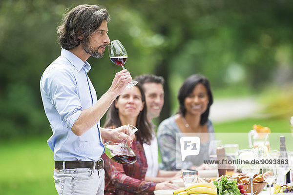 Man tasting red wine on a garden party