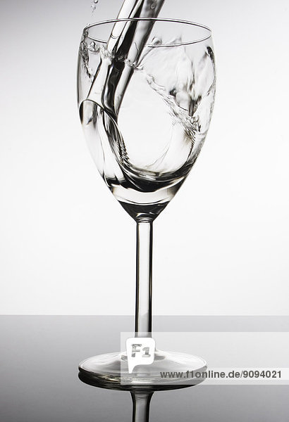 Wasser  das in ein Weinglas fließt