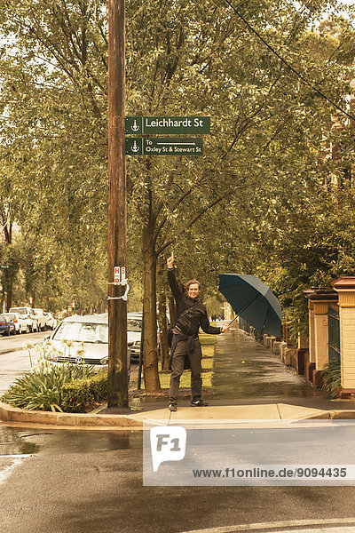 Australia,  New South Wales,  man pointing on street sign