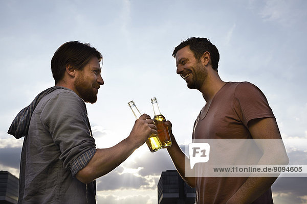 Zwei Freunde mit Bierflaschen im Freien