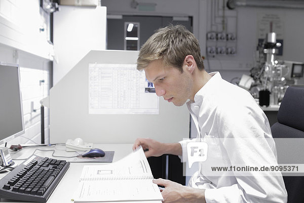 Scientist sitting at desk reading documents