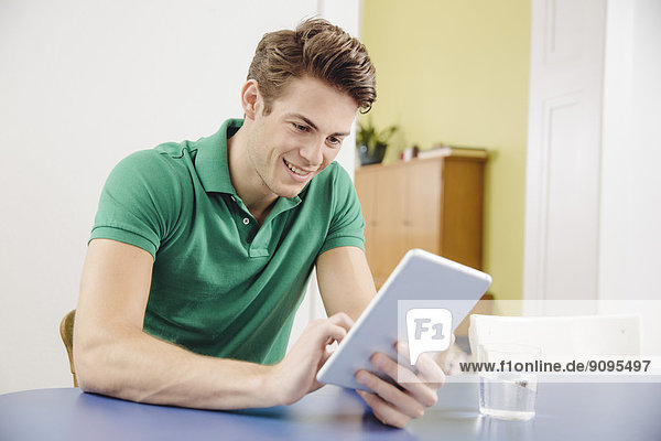 Porträt eines jungen Mannes mit Tablet-Computer zu Hause