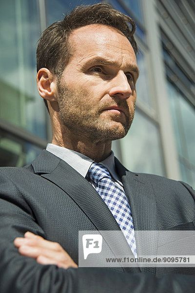 Businessman with arms crossed outdoors