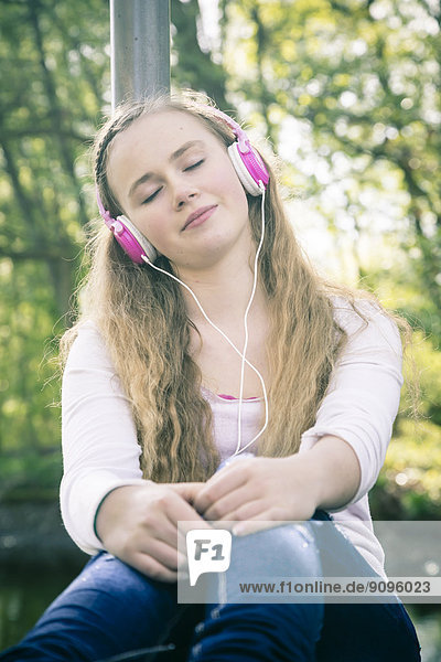 Porträt einer Teenagerin mit rosa Kopfhörer Tagträumen