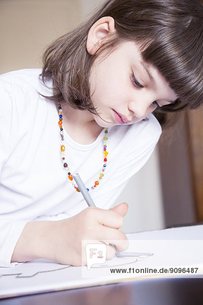 Portrait of little girl painting with wax crayon