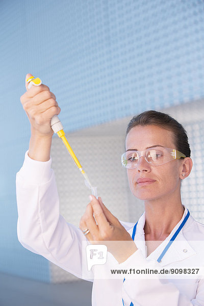 Wissenschaftler mit Pipette und Reagenzglas im Labor