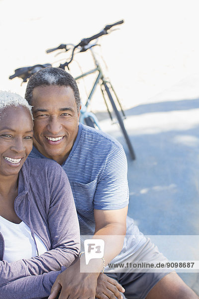 Porträt eines lächelnden Seniorenpaares neben dem Fahrrad