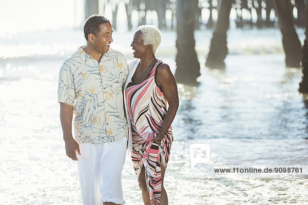 Senior couple walking on sunny beach