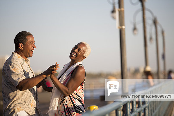 Seniorenpaar tanzt am Pier