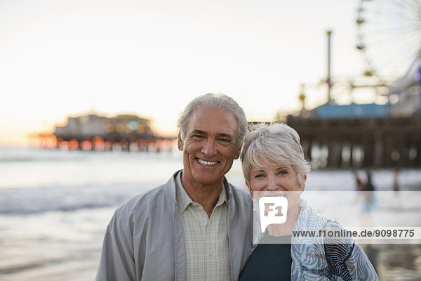 Porträt eines lächelnden Seniorenpaares am Strand