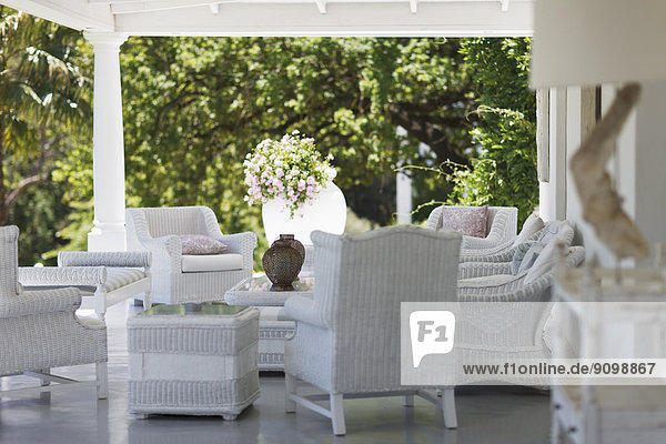 Weiße Korbmöbel auf luxuriöser Terrasse